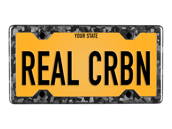 Forged carbon fiber license plate frame with 4-hole minimal design and gloss finish on yellow plate reading REAL CRBN