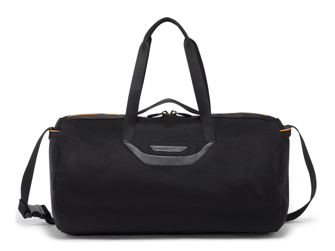 Front view of TUMI | McLaren Just In Case® Duffel in black with shoulder strap and orange trim.