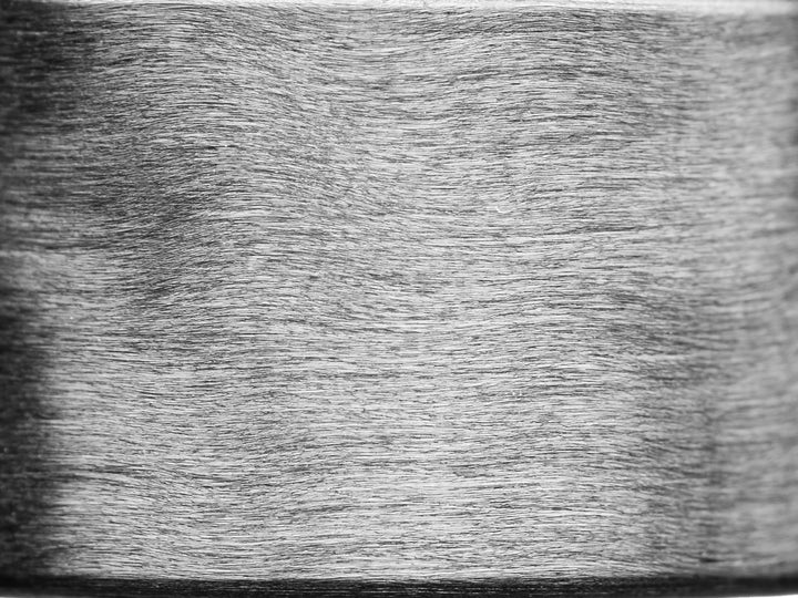 Extreme close-up of uni-directional carbon fiber grain texture, showing linear matte finish and fine fiber alignment