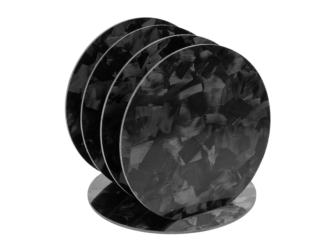 An array of CarbonFG forged carbon fiber coasters fanned out on display, each showcasing the one-of-a-kind marbled pattern characteristic of forged carbon.