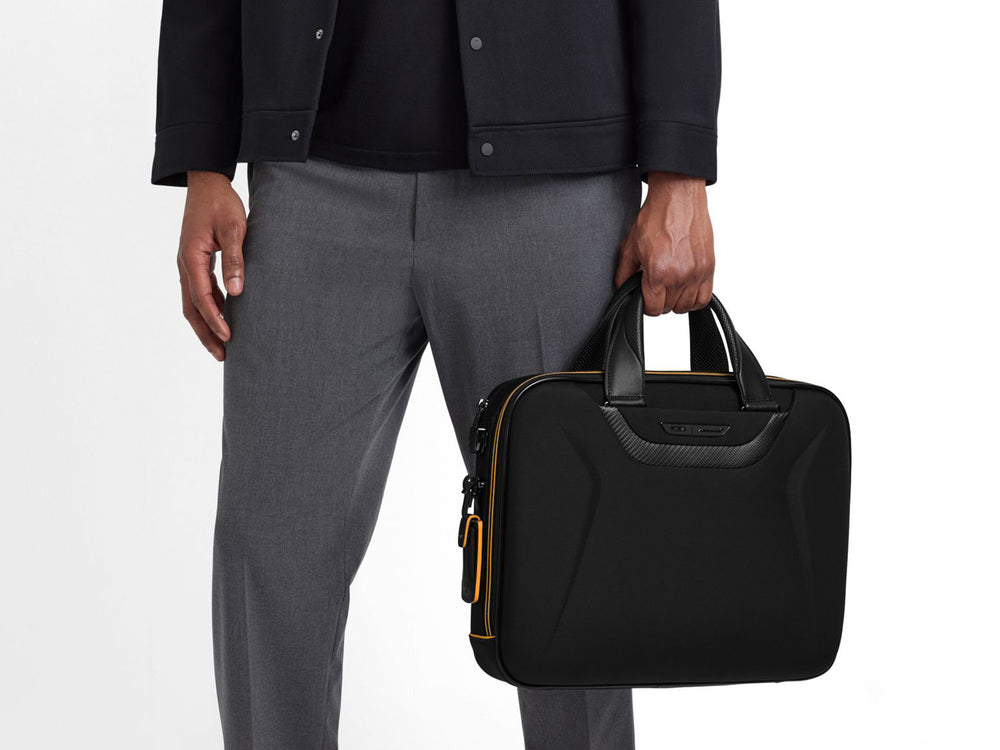 TUMI | McLaren Axle carbon fiber Slim Brief, being held by a model