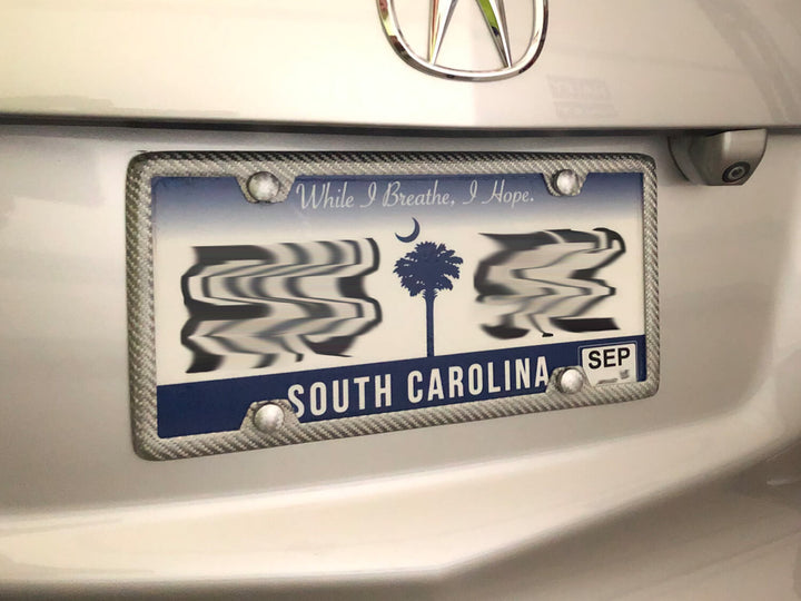 Silver carbon fiber fiberglass license plate frame on Acura MDX