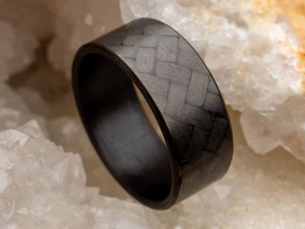 8mm carbon fiber ring with 45° twill weave pattern, displayed in crystal geode for a bold contrast and detail-focused shot