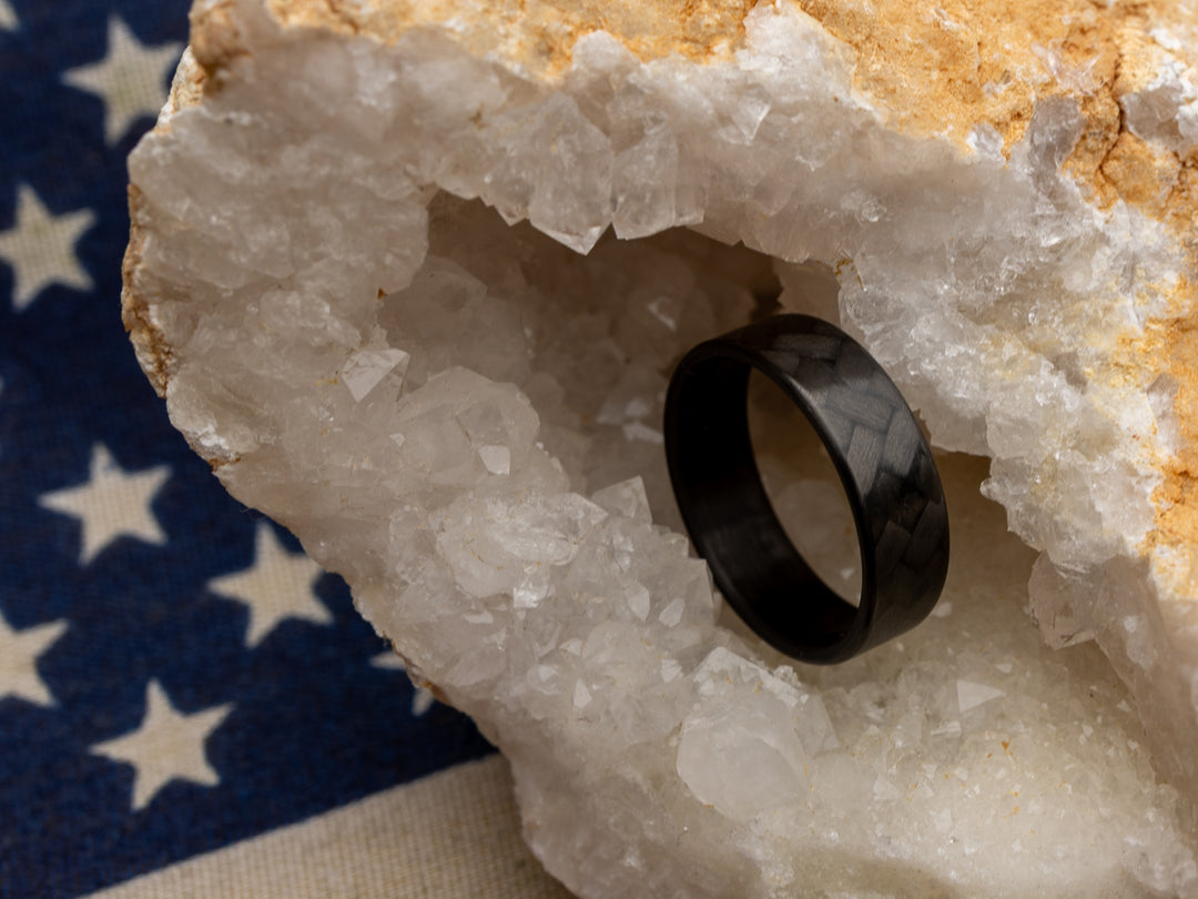 Carbon fiber ring with 45° weave in crystal geode, placed over American flag backdrop for patriotic styling