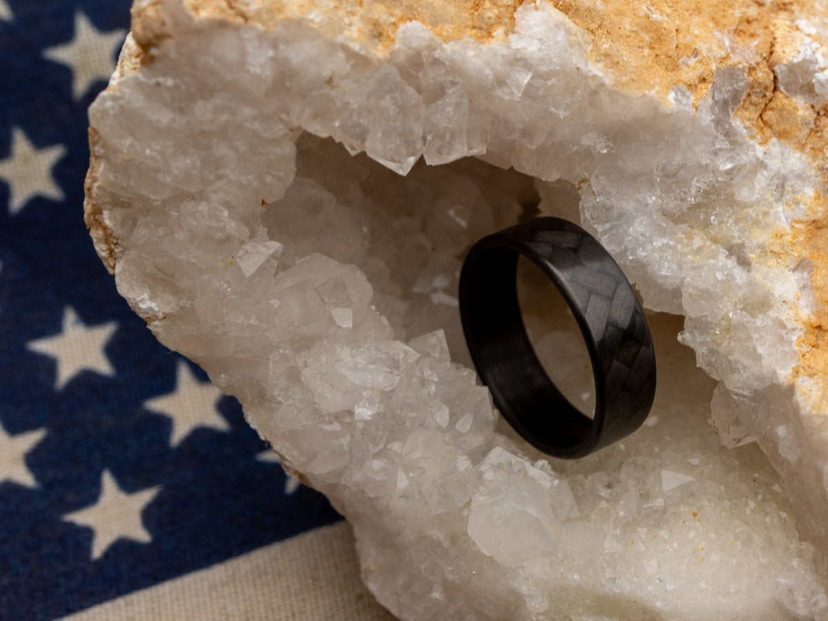 Carbon fiber ring with 45° weave in crystal geode, placed over American flag backdrop for patriotic styling