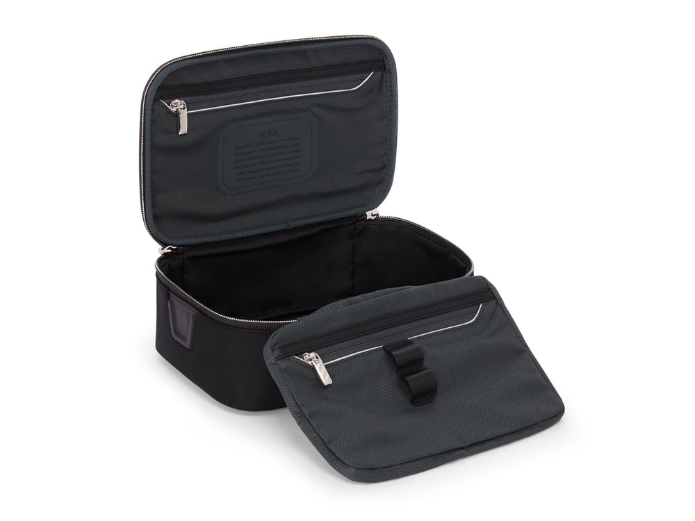 TUMI Richards travel kit open showing water-resistant compartment and interior zip pockets with elastic loops