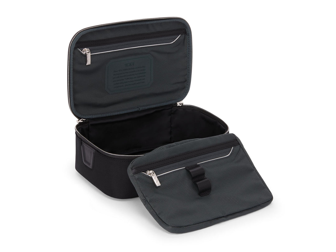 TUMI Richards travel kit open showing water-resistant compartment and interior zip pockets with elastic loops