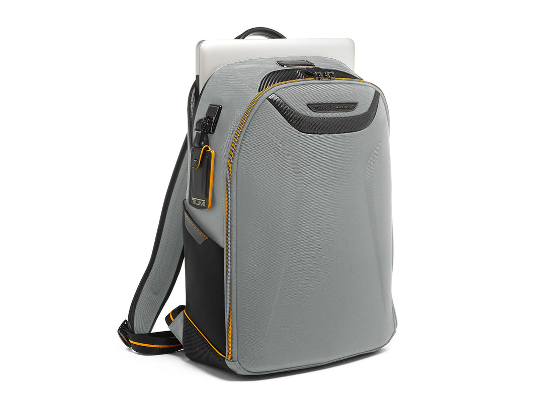 Three-quarter view of TUMI McLaren Velocity backpack in grey showing laptop sleeve and ergonomic design