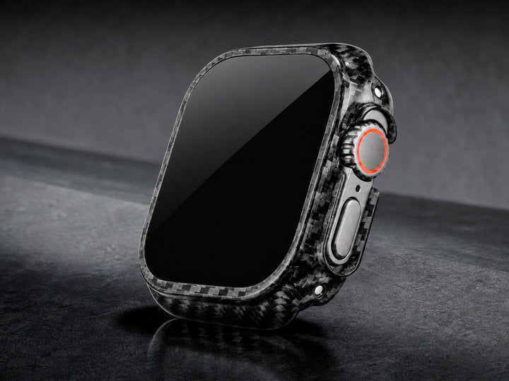 CarbonFG CarboShield carbon fiber bumper case installed on Apple Watch Ultra, dramatic angled view on dark surface