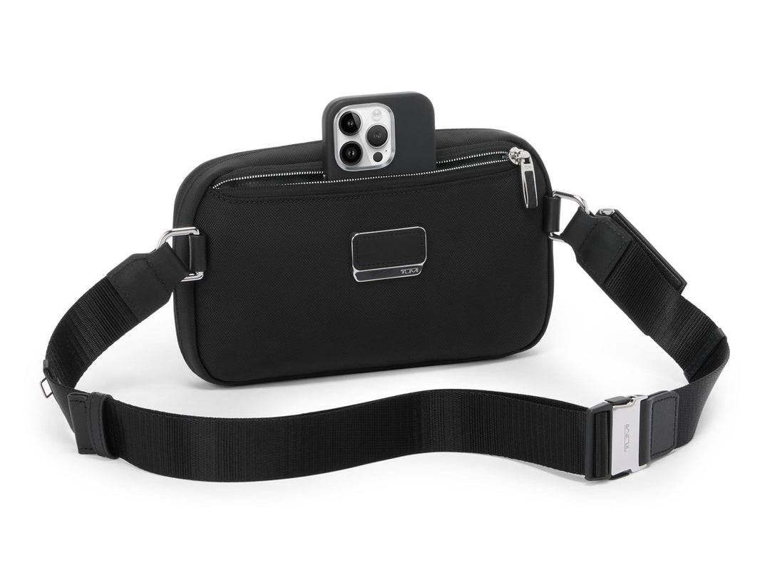 TUMI Messina sling bag front view showing phone storage and adjustable strap with metal buckle