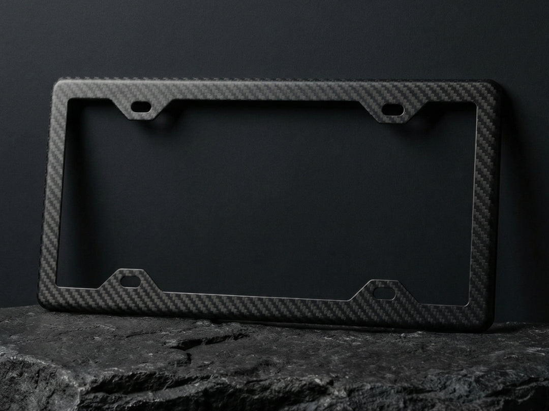 Black carbon fiber license plate frame on a dark background