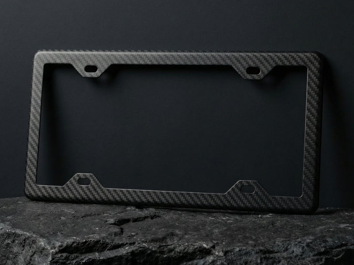 Black carbon fiber license plate frame on a dark background