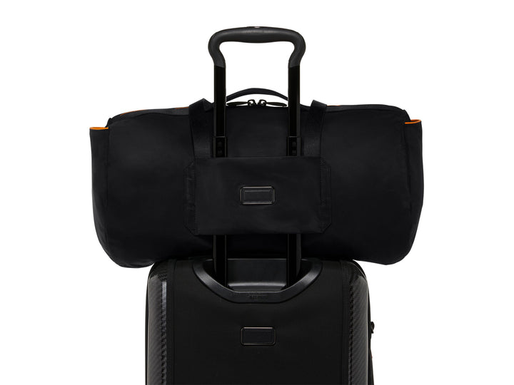 TUMI | McLaren duffel bag mounted on a suitcase handle, highlighting the Add-a-Bag strap.