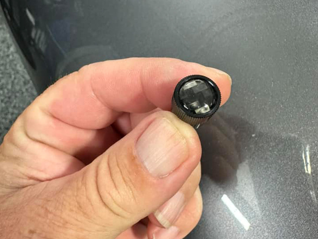 Hand holding black stem cap