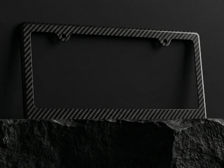 Carbon fiber patterned license plate frame on a dark background