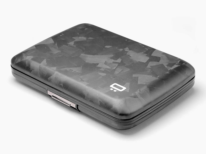 Angled side view of a forged carbon fiber wallet, showcasing its slim profile and precision metal clasp.