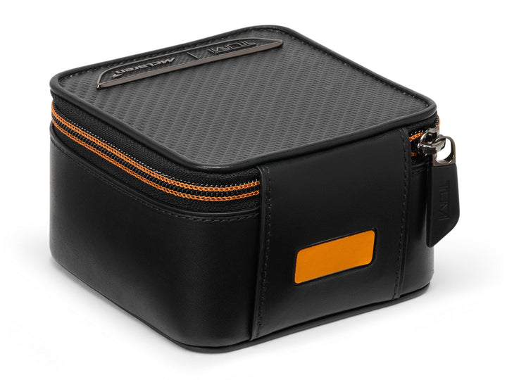 TUMI x McLaren Watch Case showing premium leather construction, CX6 carbon fiber panel, and McLaren Papaya accent badge