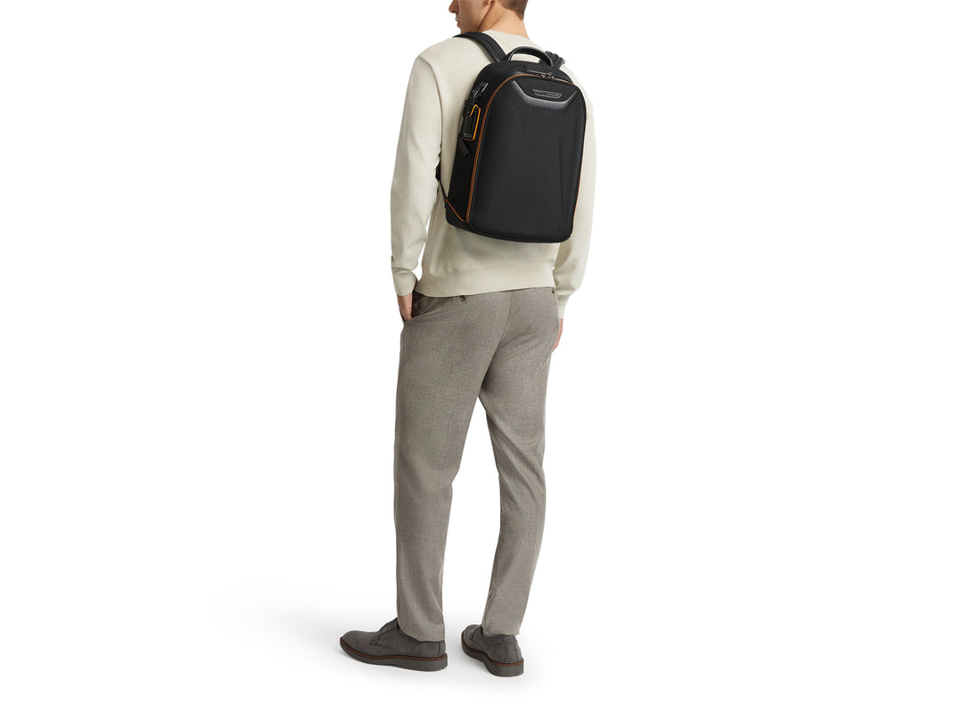 Lifestyle photo of model wearing TUMI McLaren Velocity backpack in black with business casual attire