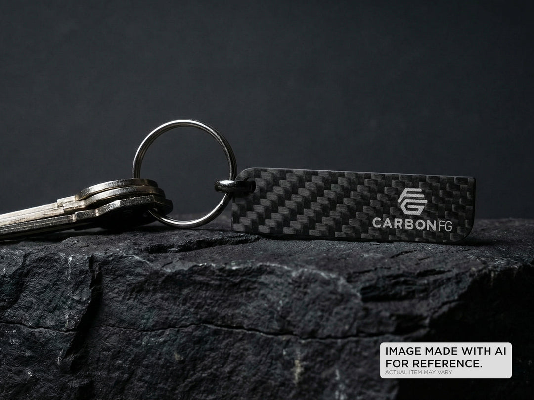 Carbon fiber keychain with 'CARBONFG' branding on a dark surface