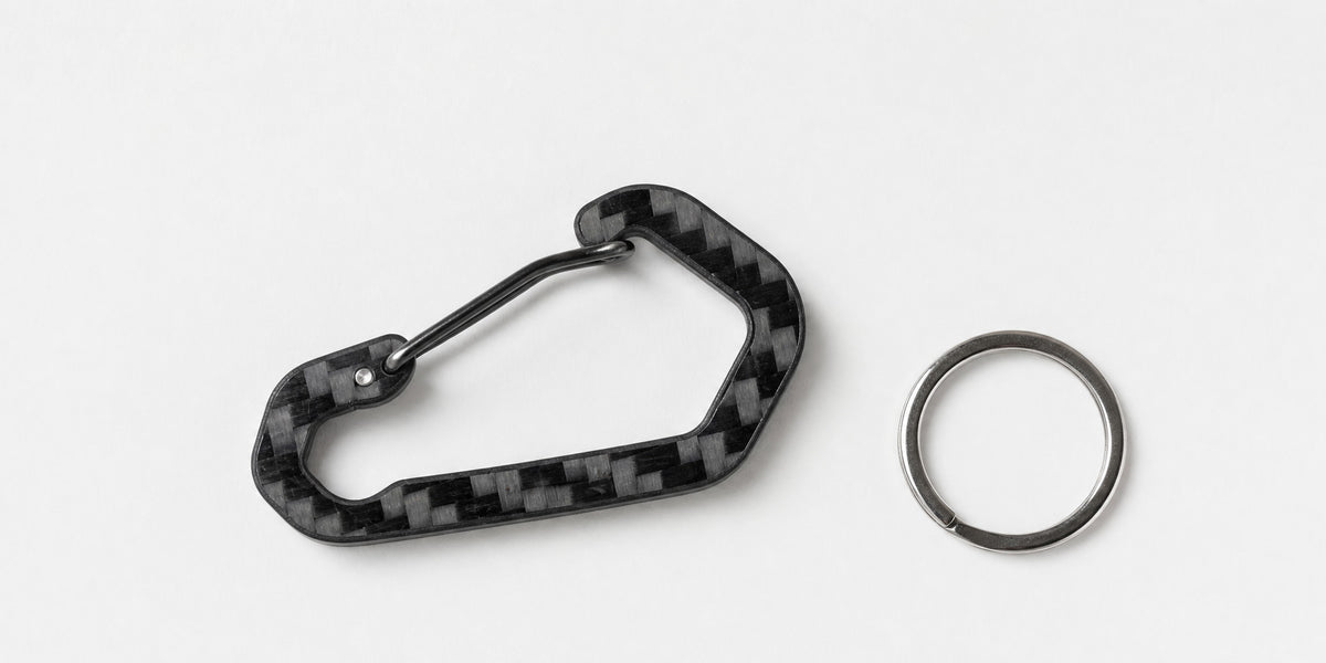 CarbonFG HexClip CF carbon fiber carabiner keychain flatlay with removable stainless steel key ring, 3K twill weave semi-gloss finish