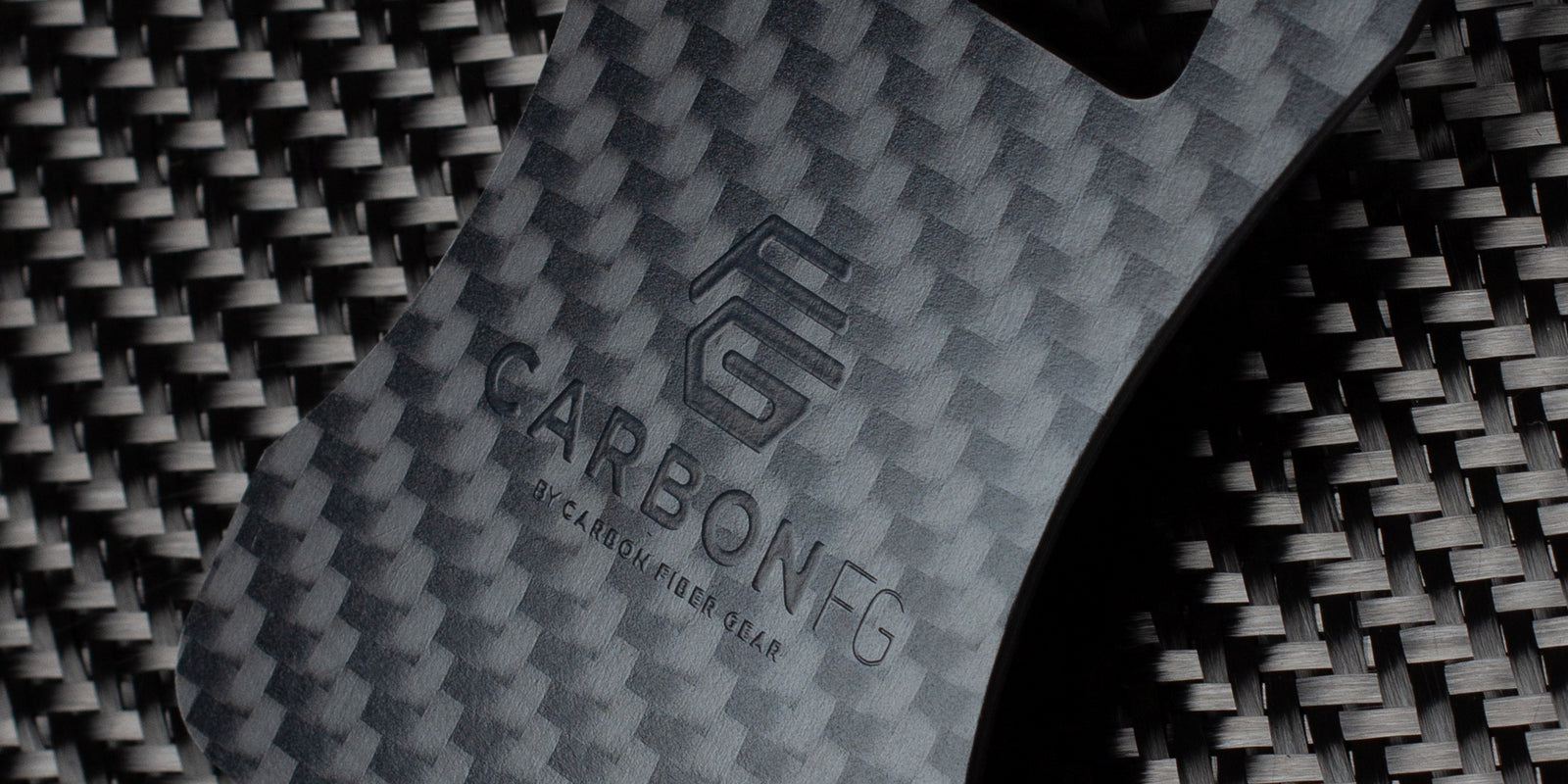Close-up of the CarbonFG Carbon Fiber Credit Card Bottle Opener with detailed twill weave carbon fiber pattern and subtle black logo embossing.