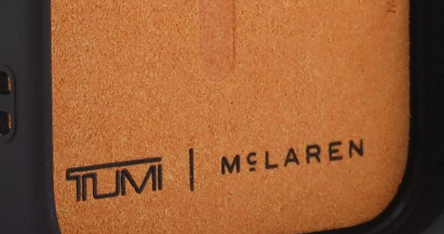 Papaya microfiber lining inside the TUMI x McLaren iPhone 18 case, with the MagSafe outline and the TUMI x McLaren mark