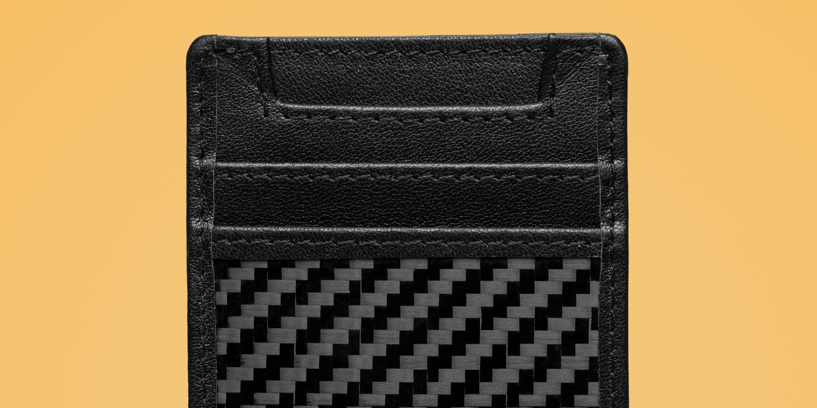 Close-up shot of the wallet showcasing the carbon fiber weave and the rich leather texture.