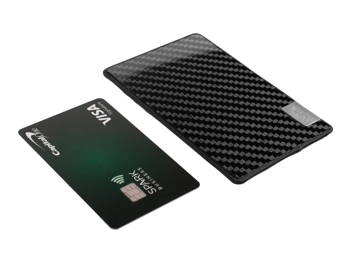 Showing how slim the Common Fibers black line LFT ultra slim carbon fiber and leather wallet is next to a credit card