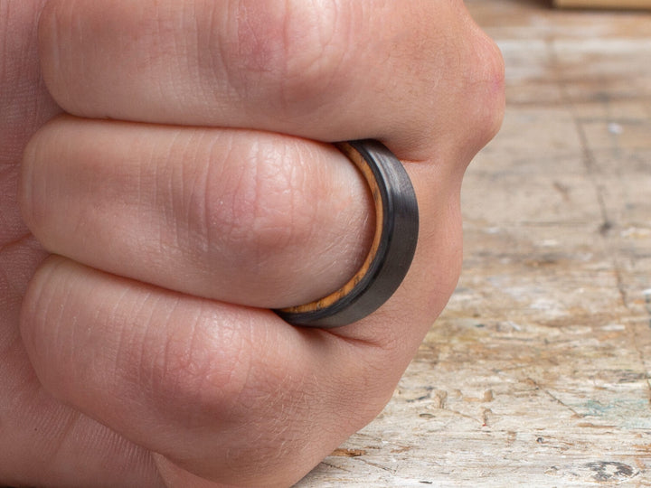 Carbon fiber and whiskey barrel cooper ring on hand