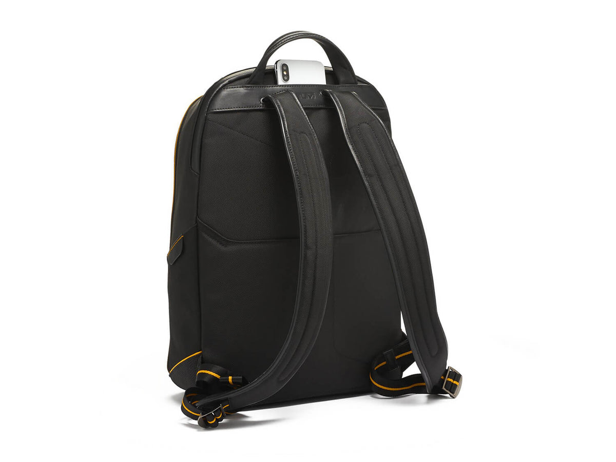 Back view of TUMI | McLaren Velocity Backpack, emphasizing ergonomic shoulder straps and McLaren Papaya detailing.
