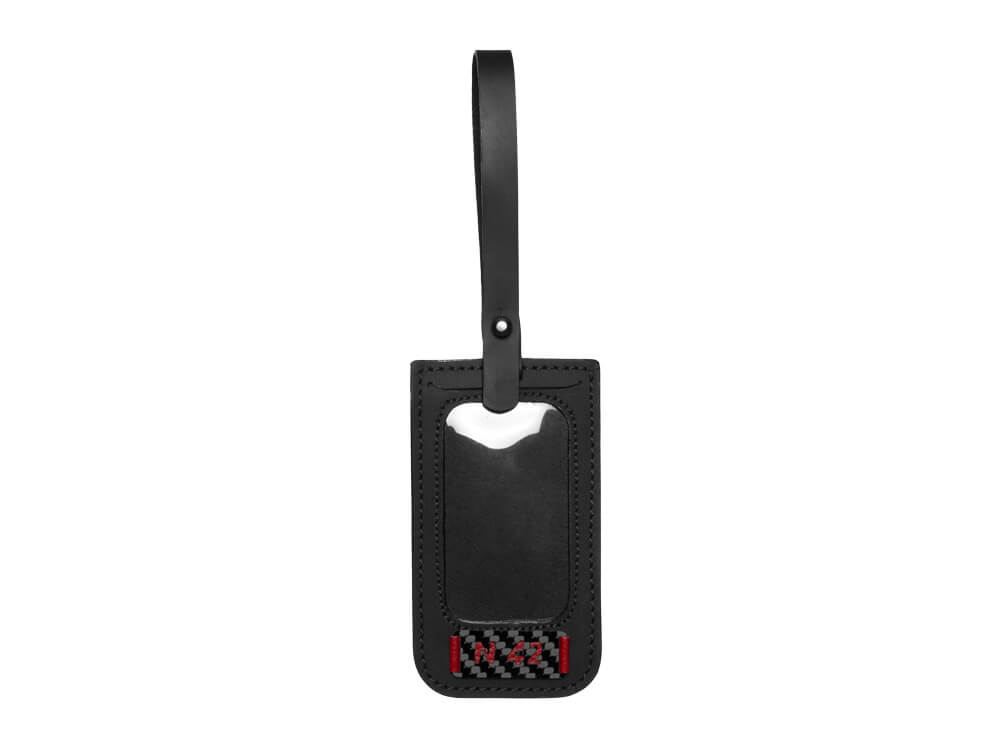 Sophisticated leather luggage tag with carbon fiber detail, enhancing the travel bag's luxurious design.
