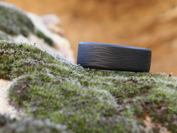 Wave carbon fiber ring on moss