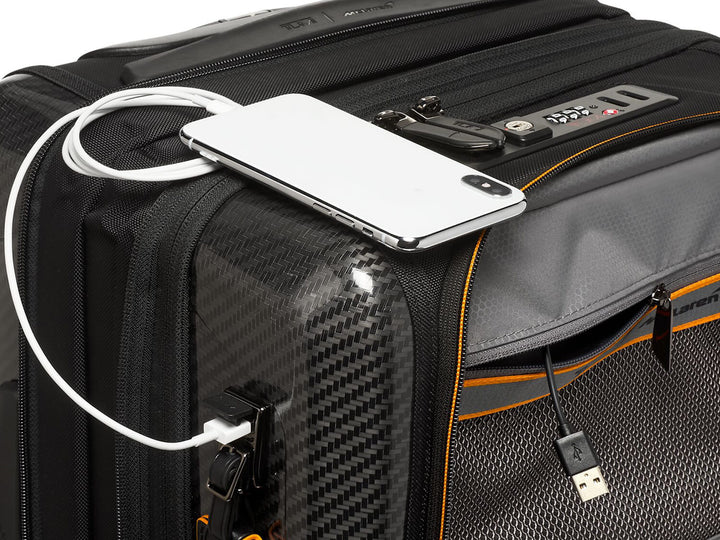 TUMI x McLaren Aero expandable 4 wheel carry-on suitcase, up close charging#color_black-with-papaya