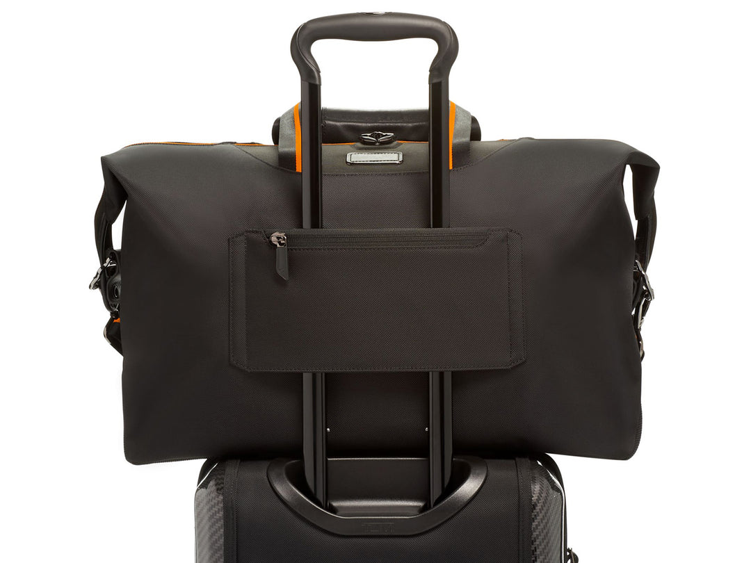 TUMI | McLaren M-Tech Soft Satchel, attached to luggage